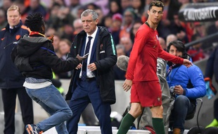 Plusieurs spectateurs sont descendus sur la pelouse pour prendre une photo avec Ronaldo, lors de Portugal-Pays-Bas, le 26 mars 2018.