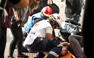 Des bénévoles de la Croix-Rouge viennent au secours d'un manifestant à Santiago, le 14 mai 2015