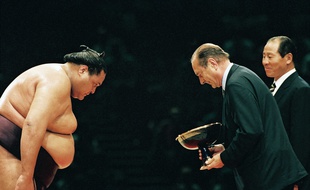 Jacques Chirac remet la coupe a Taro Akebono premier vainqueur du grand tour noi de sumo, au Palais Omnisports de Paris Bercy. Paris, FRANCE - 14/10/1995