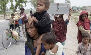 Des familles pakistanaises fuient leurs maisons après les inondations en août 2010.