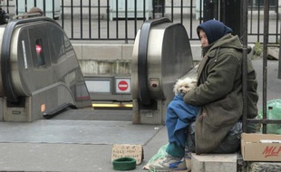Une femme mendie à la sortie d'une bouche du métro parisien, le 22 novembre 2010