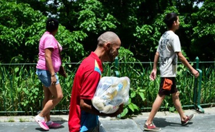 Un homme porte un sac rempli de produits alimentaires de base à Caracas, le 4 juin 2016