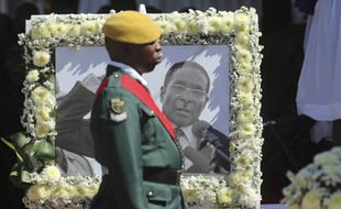 Un soldat devant un portrait de Robert Mugabe, lors des funérailles de l'ancien président à Kutama le 28 septembre 2019.