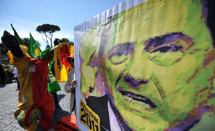 Des partisans du "Oui" au référendum sur la politique nucléaire, la privatisation de l'eau et l'immunité judiciaire du Premier ministre brandissent une affiche parodiant Silvio Berlusconi, le président du Conseil le 13 juin 2011.