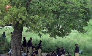 Des policiers pakistanais se reposent à l'ombre d'un arbre à Islamabad le 13 août 2014, où la situaiton est tendue à la veille de manifestations de l'opposition
