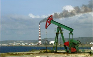 Un derrick de pétrole et une raffinerie près de la Havane, le 6 mai 2004