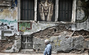Une personne passe devant un graffiti dans les rues d'Athènes, le 28 juin 2015