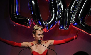 Miley Cyrus brandissant le mot LOVE (amour), lors du gala de l'AMFAR en juin 2015