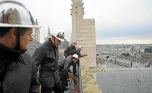 Les pompiers, en uniforme de 1972, sont montés hier sur le toit de l'édifice.