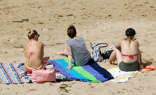 Des jeunes femmes assises sur la plage de Saint-Malo, en juillet 2016.
