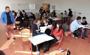 Des élèves du Microlycée du Val-de-Marne travaillent sous le regard d'Eric de Saint-Denis (g), un des professeurs et responsables de la structure, le 10 octobre 2008 à Vitry-sur-Seine, près de Paris