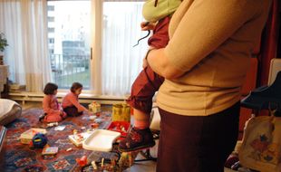 Une assistante maternelle gardant des enfants à domicile (illustration)