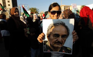 Le portrait du général dissident Khalifa Haftar est brandi par une partisane qui manifeste le 23 mai 2014 à Benghazi, dans l'est du pays, en soutien de l'action menée par cet officier décidé à en finir avec les "groupes terroristes"
