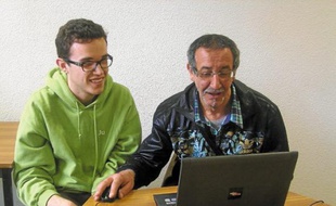 Miloud (à dr.), assisté par Julien, étudiant, apprend à répondre aux offres d'emploi sur Internet.