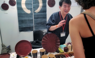 Goro Koizumi, artisan japonais, explique sa techique le Kamakura Bori aux visiteurs de la Japan Expo