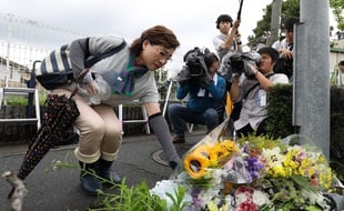 Une femme dépose des fleurs en hommage aux victimes de l'incendie de Kyoto Animation, le 19 juillet 2019.