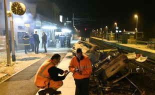 Des agents SNCF et la police près de voitures calcinées sur les voies ferrées devant la gare de Moirans, le 20 octobre 2015