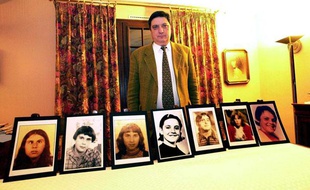 Pierre Monnoir, president de l'Association de défense des handicapés de l'Yonne presente les portraits des «Disparues de l'Yonne» à Auxerre, le 16 décembre 2000.