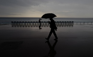 Un homme marche sous la pluie à Nice