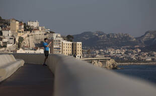 Un homme prend un photo sur la Corniche à Marseille