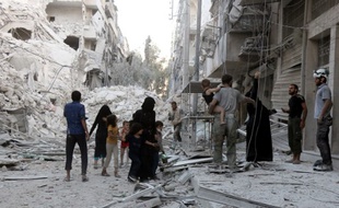 Une famille syrienne quitte un quartier qui vient d'être bombardé par les aviations russe et syrienne, le 23 septembre 2016, dans le nord d'Alep (Syrie).