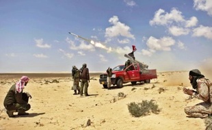 Des insurgés tirent sur des pro-Kadhafi, hier près de Brega.