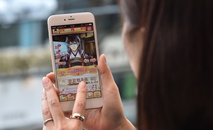 Une femme jouant à un jeu de simulation romantique ultra populaire, la série d'applications Ikemen