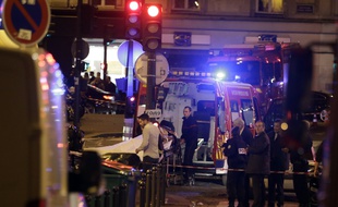 An injured person is evacuate following an attack in the 10th arrondissement of the French capital Paris, on November 13, 2015. At least 18 people were killed as multiple shootings and explosions hit Paris, police said. Police also said there was an ongoing hostage crisis in the Bataclan a concert hall in the French capital. AFP PHOTO / KENZO TRIBOUILLARD