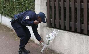 Un policier dépose des fleurs en hommage à ses collègues tués dans une attaque au couteau près de leur domicile à Magnanville, à l'ouest de Paris, en juin 2016.