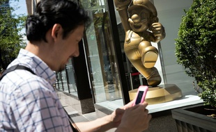 L'application Pokemon Go sur smartphone rencontre un succès phénoménal depuis son lancement la semaine dernière, attirant des millions de fans, comme à New York, le 11 juillet 2016, devant un magasin Nintendo