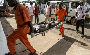 Une personne blessée, lors de violences provoquée par l'assassinat d'un conducteur de moto-taxi, arrive sur une civière à l'hôpital de Bangui, le 26 septembre 2015 en Centrafrique