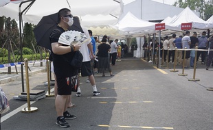 Pékin (Chine), le 19 juin 2020. Des Chinois patientent avant de subir un test pour savoir s'ils sont porteurs du coronavirus.