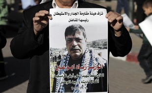 Un palestinien porte le portrait de Ziad Abu Ain, mort le 10 décembre 2014.