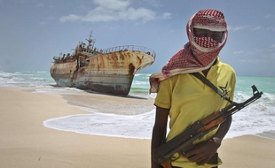 Un pirate somalien, le visage masqué, se tient devant un navire taïwanais, le 23 septembre 2012