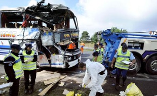 Des gendarmes s'activent, le 23 août 2008 autour d'un bus de supporters de l'OM qui se rendait au Havre et qui a percuté le pilier d'un pont sur l'autoroute A6 près de Fontainebleau (Seine-et-Marne), faisant deux morts, cinq blessés graves et 15 blessés légers..
