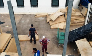 Des migrants se tiennent près d'un matelas près du centre d'hébergement temporaire de Lampedusa (Italie)le 8 octobre 2013