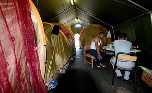 Des hommes dans un camp de fortune pour demandeurs d'asile, le 18 juillet 2014 à Grenoble