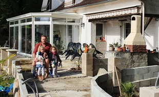 Olivier et ses deux petites filles devant sa maison en Dordogne.