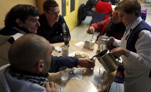 Sous la neige qui tombe pour la première fois de l'hiver, ils se pressent à l'entrée du centre d'accueil de Caritas à Burgos, dans le nord de l'Espagne. Immigrés, femmes, chômeurs, ils ont les multiples visages de la pauvreté qui grandit dans ce pays en crise.