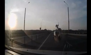 Ce motard percute une voiture et se réceptionne sur le toit.