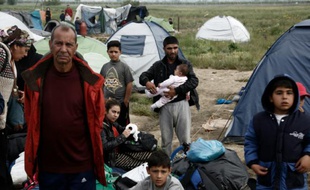 Des réfugiés attendent d'être transférés par bus lors de l'évacuation du camp d'Idomeni le 24 mai 2016