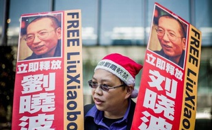 Une vidéo mise en ligne lundi montre plusieurs dissidents forçant le cordon de sécurité mis en place autour du domicile de la femme du prix Nobel de la paix emprisonné Liu Xiaobo, elle-même assignée à résidence à Pékin.