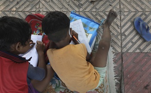 Privés d'école, deux enfants apprennent leurs leçons sur le trottoir en Inde, le 3 septembre 2020.