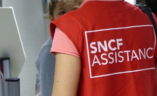 Un "gilet rouge" de la SNCF renseigne un usager