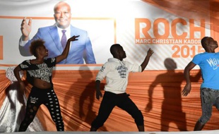 Des artistes dansent devant une affiche de Roch Marc Christian Kaboré à Ouagadougou le 1er décembre 2015