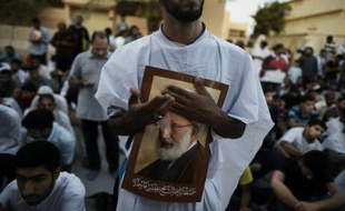 Des manifestants brandissent des portraits du cheikh Issa Qassem pour protester contre le gouvernement bahreïni qui a déchu de sa nationalité le plus haut dignitaire chiite du pays, le 20 juin à Diraz