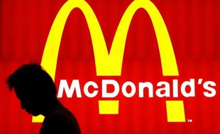 Un homme passe devant une enseigne Mc Donald's à Hong-kong.