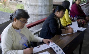 Préparatifs dans un bureau de vote avant le début des élections municipales à Rangoun, le 27 décembre 2014