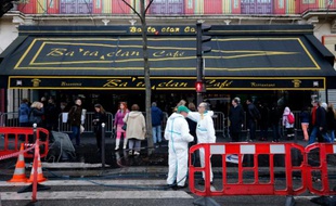 Des agents municipaux nettoient la façade et le trottoir devant le Bataclan à Paris, le 22 décembre 2015