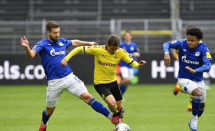 Thorgan Hazard aux prises avec le joueur de Schalke Matija Nastasic (G) lors du match de reprise de la Bundesliga entre le BVB Borussia Dortmund et Schalke 04, le 16 mai 2020 à Dortmund.
